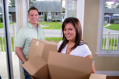 Removalists carrying furniture through a Barnet home